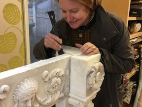 This undated photo provided by interior designer Heidi Pribell shows Pribell unfixing the 1805 marble mantlepiece from the wall of a home in Boston. Pribell sold the mantlepiece to the Museum of Fine Arts later. When Pribell spotted a dust-covered mantelpiece in the basement of a client's newly purchased home, it was the start of a long relationship.(Rhea Nawar/Heidi Pribell via AP)