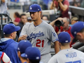 Los Angeles Dodgers pitcher Yu Darvish greets teammates in the dugout before pitching against the New York Mets in a baseball game, Friday, Aug. 4, 2017, in New York. (AP Photo/Julie Jacobson)