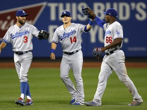 Los Angeles Dodgers left fielder Chris Taylor (3), center fielder Enrique Hernandez (14) and right fielder Yasiel Puig (66) celebrate after the Dodgers 8-0 shut out of the New York Mets in a baseball game Sunday, Aug. 6, 2017, in New York. (AP Photo/Kathy Willens)