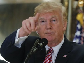 President Donald Trump points to members of the media as he answers questions in the lobby of Trump Tower in New York, Tuesday, Aug. 15, 2017. (AP Photo/Pablo Martinez Monsivais)