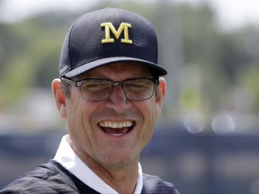 This July 17, 2017 photo shows Michigan football coach Jim Harbaugh in Ann Arbor, Mich. It's game week for Michigan, and Harbaugh is playing games of another kind -- keeping his roster secret. He also won't say whether returning starter Wilton Speight or seldom-used senior John O'Korn will take the first snap for the 11th-ranked Wolverines against No. 17 Florida in Texas in the opener for both schools. (AP Photo/Carlos Osorio)