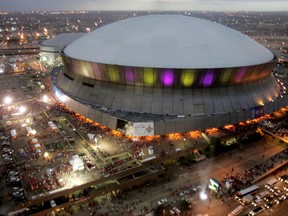 FILE - In this Jan. 7, 2008, file photo, color lights play on the Louisiana Superdome at twilight before the BCS championship college football game in New Orleans. The BYU-LSU game will be played Saturday, Sept. 2, 2017 at the Superdome in New Orleans after massive flooding in Houston from Hurricane Harvey forced it to be relocated from NRG Stadium. (AP Photo/Rob Carr, File)