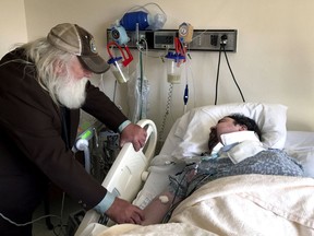 In this April 18, 2017, photo, Walter Wenger visits his severely disabled son, Steven, in a hospital in Kingston, N.Y, where he was moved after maggots were twice found in the area around his breathing tube while living in a state group home. The Associated Press obtained a confidential report on the state investigation that determined the 2016 infestations at the group home in Rome, N.Y., were the result of neglect by caregivers. In most states, details of abuse and neglect investigations in state-regulated institutions for the disabled are almost never made public. (AP Photo/David Klepper)