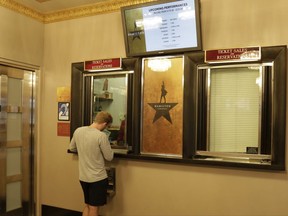 A theater goer purchases a ticket to the Broadway show "Hamilton" at the Richard Rogers Theatre, in New York's Theater District, Friday, Aug. 18, 2017. The still incredibly popular show "Hamilton" announced this week that it would be the latest to offer up a new block of tickets for sale using new technology, called "Verified Fan," to try to keep re-sellers and brokers from snapping them all up. (AP Photo/Richard Drew)