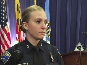 File-This Oct. 26, 2015, file photo shows Officer Hannah Parish displaying a Taser International Axon Camera body camera during a news conference  in Baltimore. The Baltimore Police Department is having a tough time restoring public confidence in the troubled agency. The city is on pace to break its decades-old murder record and the body camera program that was rolled out to increase transparency has fueled allegations of misconduct after a pair of problematic videos recently surfaced. (AP Photo/Juliet Linderman, File)