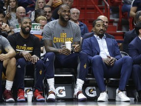 File-This March 4, 2017, file photo shows Cleveland Cavaliers' Kyrie Irving, left, LeBron James, center, and J.R. Smith, right, watching from the bench during the first half of an NBA basketball game against the Miami Heat, in Miami. Last season, when stars like James, Irving, Kevin Love, Stephen Curry, Klay Thompson, Draymond Green and Andre Iguodala all were given nights off when the Cavaliers or Warriors were playing nationally televised games on ABC, there was no shortage of scorn. This season, teams playing in those marquee ABC games will have a day off both before and after those contests.(AP Photo/Lynne Sladky)