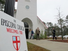 FILE - In a Dec. 16, 2012 file photo, members of the Conway Worship Group gather at the chapel at Coastal Carolina University in Conway, S.C. The members of the fledgling congregation left their home church after it decided to follow the Diocese of South Carolina and leave the national Episcopal Church in disputes over ordaining homosexuals and other issues. According to a split ruling issued Wednesday, Aug. 2, 2017, by the South Carolina Supreme Court dozens of parishes that split with The Episcopal Church over theological issues cannot take valuable real estate with them.  (AP Photo/Bruce Smith, File)