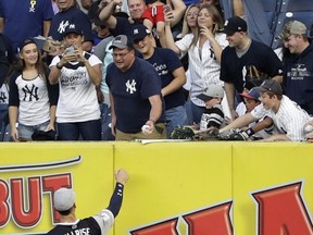 New York Yankees right fielder Aaron Judge hands a ball to fans wearing a jersey with his nickname on the back before a baseball game against the Seattle Mariners on Friday, Aug. 25, 2017, in New York. (AP Photo/Frank Franklin II)