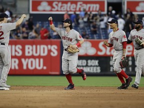 Boston Red Sox's Brock Holt, left, celebrates with teammates Andrew Benintendi, second from left, Mookie Betts and Jackie Bradley Jr., right, after a baseball game against the New York Yankees, Saturday, Aug. 12, 2017, in New York. (AP Photo/Frank Franklin II)