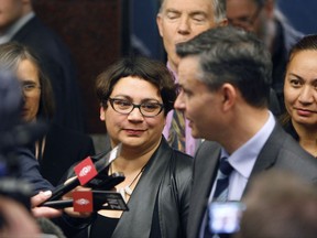 In this Tuesday, Aug. 8, 2017, photo, Green Party co-leaders Metiria Turei, center, and James Shaw, right, answer questions from reporters in Wellington, New Zealand. Turei resigned Wednesday, three weeks after confessing she committed welfare fraud as a struggling young mother more than 20 years ago. (AP Photo/Nick Perry)