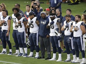 Los Angeles Rams linebacker Robert Quinn, center, raises his fist during the national anthem before an NFL preseason football game against the Oakland Raiders in Oakland, Calif., Saturday, Aug. 19, 2017. (AP Photo/Jeff Chiu)