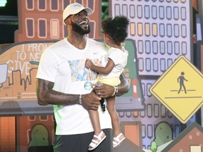 Cleveland Cavaliers' LeBron James laughs as he leaves the stage holding his daughter, Zhuri, during the We Are Family Reunion at Cedar Point in Sandusky, Ohio, Tuesday, Aug. 15, 2017. (Erin McLaughlin/The Sandusky Register via AP)