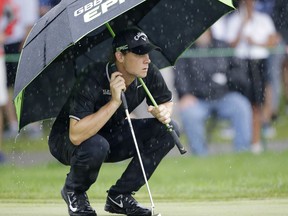 Thomas Pieters, from Belgium, waits to putt on the first green as rain falls during the second round of the Bridgestone Invitational golf tournament at Firestone Country Club, Friday, Aug. 4, 2017, in Akron, Ohio. (AP Photo/Tony Dejak)