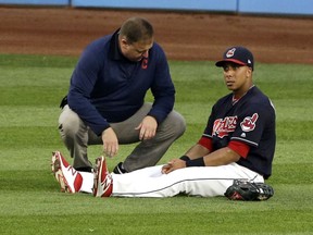 Cleveland Indians' Michael Brantley, right, is looked at by a trainer in the fifth inning of a baseball game against the Colorado Rockies, Tuesday, Aug. 8, 2017, in Cleveland. Brantley left the game in the fifth inning. (AP Photo/Tony Dejak)