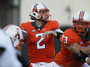 Oklahoma State quarterback Mason Rudolph (2) looks for a receiver, behind offensive lineman Teven Jenkins (73) during the first half of an NCAA college football game against Tulsa in Stillwater, Okla., Thursday, Aug. 31, 2017. (AP Photo/Sue Ogrocki)