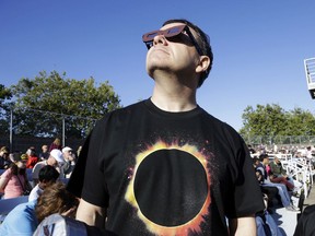 Lee Cooper, from England, wears his protective glasses to watch the beginning of the solar eclipse from Salem, Ore., Monday, Aug. 21, 2017. (AP Photo/Don Ryan)