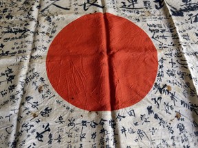 In this Monday, Aug. 7, 2017 photo, names are visible on a Japanese flag owned by WWII veteran Marvin Strombo in Portland, Ore. Strombo recovered the flag from a dead Japanese soldier in the Pacific more than 70 years ago and now, at age 93, will return the flag to the Japanese man's surviving siblings. (AP Photo/Don Ryan)