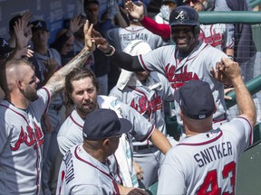 Atlanta Braves' Brandon Phillips, top right, celebrates scoring with teammates on a home run by Freddie Freeman during the first inning of the first baseball game of a doubleheader against the Philadelphia Phillies, Wednesday, Aug. 30, 2017, in Philadelphia. (AP Photo/Chris Szagola)