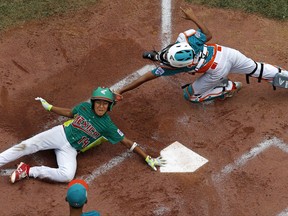 Reynosa, Mexico's Cesar Monjaraz (14) slides around the attempted tag by Maracaibo, Venezuela, catcher Luis Rodriguez to score during the second inning of an international elimination baseball game at the Little League World Series in South Williamsport, Pa., Tuesday, Aug. 22, 2017. Mexico won 8-0.(AP Photo/Gene J. Puskar)