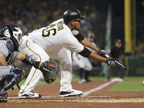 Pittsburgh Pirates' Ivan Nova, right, lays down a bunt in front of San Diego Padres catcher Austin Hedges during the fifth inning of a baseball game, Friday, Aug. 4, 2017, in Pittsburgh. Nova was safe at first on a throwing error by Hedges that allowed Francisco Cervelli to score. Nova was thrown out trying to take second on the play.(AP Photo/Keith Srakocic)