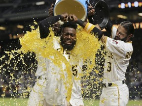 Pittsburgh Pirates' Josh Harrison (5) has a bucket of sports drink and ice dumped over his head by teammates Sean Rodriguez (3) and Josh Bell, left, as he is interviewed after hitting a walk-off home run to beat the Los Angeles Dodgers and break up the no-hitter by Dodgers starting pitcher Rich Hill in the tenth inning of a baseball game, Wednesday, Aug. 23, 2017, in Pittsburgh. The Pirates won 1-0 in ten innings.(AP Photo/Keith Srakocic)