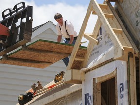 In this Thursday, June 1, 2017, photo, builders work on the roof of a home under construction at a housing plan in Jackson Township, Butler County, Pa. The National Association of Home Builders/Wells Fargo releases its August index of builder sentiment, Tuesday, Aug. 15, 2017. (AP Photo/Keith Srakocic)