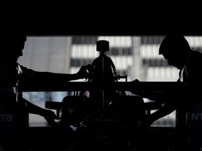Crew members work on the car of Tony Kanaan before practice for Sunday's IndyCar auto race, Saturday, Aug. 19, 2017, in Long Pond, Pa. (AP Photo/Matt Slocum)