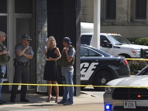 Officials consult near the crime scene at the Huntington Bank,  next to the Courthouse  in Steubenville, Ohio, Monday Aug. 21, 2017, after Jefferson County Judge Joseph Bruzzese Jr. was ambushed and shot while walking to work early Monday morning. (Darrell Sapp/Pittsburgh Post-Gazette via AP)