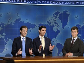 This August 10, 2017, photo provided by NBC shows Alex Moffat as Eric Trump, left, Mikey Day as Donald Trump Jr., center, and Colin Jost on set during the debut episode of "Weekend Update: Summer Edition," in New York. The "Saturday Night Live" spinoff runs through the end of the month.  (Rosalind O'Connor/NBC via AP)