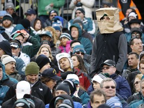 FILE - In this Nov. 22, 2015, file photo, a fan wears a paper bag on his head in the stands of Lincoln Financial Field during the second half of an NFL football game between the Philadelphia Eagles and the Tampa Bay Buccaneers in Philadelphia. The obituary for an Eagles fan who died Aug. 18, 2017, stated that he wanted 8 members of the team to serve as pallbearers so the Eagles could let him down "one last time." (AP Photo/Julio Cortez, File)