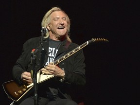 FILE - In this Jan. 15, 2014, file photo, Joe Walsh of The Eagles performs on the "History of the Eagles" tour at the Forum in Inglewood, California. Walsh and the rest of the Eagles announced Aug. 14, 2017, that they would be heading out on tour with the son of founding member Glenn Frey stepping in for his late father. (Photo by John Shearer/Invision/AP, File)