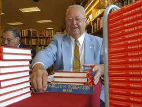 FILE – In this May 22, 2004 file photo, former York, Pa., Mayor Charles "Charlie" Robertson sets a nameplate from his time as mayor on a table before signing copies of "Murder Is the Charge," a book by his defense attorney William C. Costopoulos and Pittsburgh Tribune-Review reporter Brad Bumsted about Robertson's 2002 acquittal in the 1969 murder of black woman Lillie Belle Allen during a race riot in York, at a bookstore on the outskirts of York, Pa. Robertson, who resigned as mayor in 2002 before he was acquitted, died Thursday, Aug. 24, 2017, at age 83, according to his son. (AP Photo/Bradley C Bower, File)