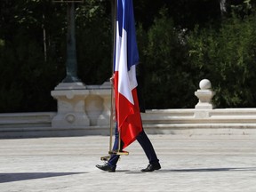 A man carries French flags before Romanian President Klaus Iohannis meets French President Emmanuel Macron in Bucharest, Romania, Thursday, Aug. 24, 2017. Macron is on a three-day tour of central and eastern Europe. (AP Photo/Vadim Ghirda)