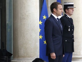 French President Emmanuel Macron and his dog Nemo, a labrador crossed griffon, waits with the President on the steps of the Elysee Palace in Paris, Monday, Aug.28, 2017. The leaders of France, Germany, Italy and Spain are meeting Monday with counterparts from Libya, Niger and Chad to discuss ways to curb illegal migration across the Mediterranean Sea to European shores. (AP Photo/Thibault Camus)
