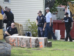 In this 2017 photo, police officers look over a slab of concrete pulled out of the basement of a home in Milton, Pa. Investigators hope cement taken from the Pennsylvania basement will solve the 1989 disappearance of Barbara Elizabeth Miller by determining if her remains were fed through wood chipper and then entombed there. Police said preliminary results showed the concrete contained wood chips and they're testing for the remains of Miller.