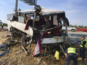 FILE - In this Aug. 2, 2016, file photo, authorities investigate the scene of a charter bus crash on northbound Highway 99 between Atwater and Livingston, Calif. The Merced County District Attorney's office on Monday, July 31, 2017, filed four felony counts of vehicular manslaughter and five misdemeanor vehicle code violations against the driver Mario David Vasquez in connection with the crash last August amid San Joaquin Valley farmland. (AP Photo/Scott Smith, File)