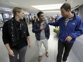 FILE- In this Feb. 8, 2017, file photo, Army Capt. Matthew Ball, right, walks with his former interpreter Qismat Amin, center, alongside Ball's wife, Giselle Rahn, after Amin arrived from Afghanistan at San Francisco International Airport in San Francisco. Amin, who worked as a translator for the US military in Afghanistan from 2010 to 2015 and now lives in Fremont, Calif., said the Trump administration's strategy outlines what every Afghan wants to hear--that the U.S. will continue having a military presence until there is stability in the country. (AP Photo/Marcio Jose Sanchez, File)