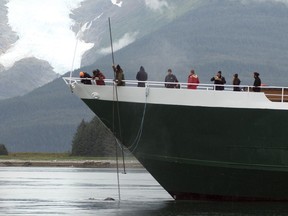 NOAA-trained marine mammal responders collect a sample from the exhalation of a humpback whale, entangled in the anchor line of a small cruise ship, on Sunday, Aug.  27, 2017, near the mouth of Tracy Arm, Alaska. The humpback whale became entangled in the anchor line south of Juneau, getting stuck for roughly 12 hours while federal authorities and the boat's crew worked to free it. (John Moran/NOAA Fisheries via AP)