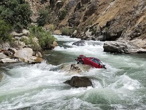 This Aug. 5, 2017, photo provided by the Fresno County Sheriff's office shows a car in the middle of Kings River near Fresno, Calif. The Fresno County Sheriff's Office has been working since July 26 on a plan to remove the car that has two bodies in it. Efforts to remove the car and retrieve the bodies are hampered by rugged terrain. (Fresno County Sheriff's Office via AP)