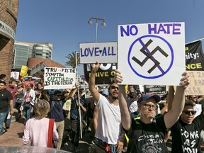 Demonstrators march in downtown Los Angeles decrying hatred and racism the day after a white supremacist rally that spiraled into violence in Charlottesville, Va.