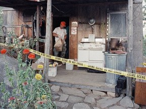 FILE - In this Aug. 31, 1992, file photo, federal agents gather evidence from the home of captured fugitive Randy Weaver near Naples, Idaho. It's been a quarter century since a standoff in the remote mountains of northern Idaho left a 14-year-old boy, his mother and a federal agent dead and sparked the expansion of radical right-wing groups across the country that continues to this day. (AP Photo/Gary Stewart, File)