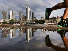 The skyline of the banking district is reflected in a puddle after a heavy thunderstorm during the night in Frankfurt, Germany, Tuesday, Aug. 1, 2017. (AP Photo/Michael Probst)