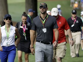 Swimmer, Michael Phelps walks the back ninth during the first round of the PGA Championship golf tournament at the Quail Hollow Club Thursday, Aug. 10, 2017, in Charlotte, N.C. (AP Photo/Chris O'Meara)