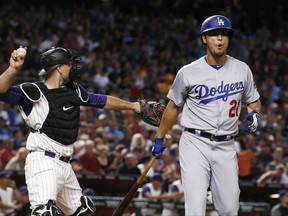 Los Angeles Dodgers' Yu Darvish (21), of Japan, makes a face after striking out as Arizona Diamondbacks' Chris Iannetta, left, throws the ball to the third baseman during the second inning of a baseball game Thursday, Aug 10, 2017, in Phoenix. (AP Photo/Ross D. Franklin)