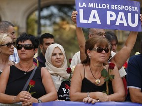 A banner reading 'Best answer is peace' is held up as people wait for the start of a demonstration condemning the attacks that killed 15 people last week in Barcelona, Spain, Saturday, Aug. 26, 2017.
