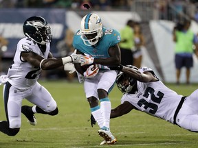Miami Dolphins' Jakeem Grant, center, is grabbed by Philadelphia Eagles' Terrence Brooks, left, and Rasul Douglas during the second half of a preseason NFL football game, Thursday, Aug. 24, 2017, in Philadelphia. (AP Photo/Michael Perez)