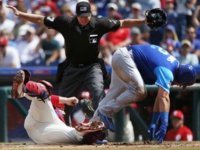 Chicago Cubs' Kyle Schwarber, right, is safe at home on a single by Anthony Rizzo before Philadelphia Phillies catcher Cameron Rupp, left, can make the tag in the first inning of a baseball game, Sunday, Aug. 27, 2017, in Philadelphia. Ben Zorbist also scored. (AP Photo/Laurence Kesterson)
