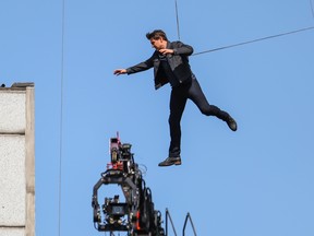 Tom Cruise jumps between two buildings in a scene from the new Mission: Impossible movie, currently filming in London.