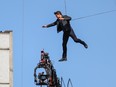 Tom Cruise jumps between two buildings in a scene from the new Mission: Impossible movie, currently filming in London.