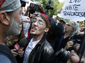 A supporter of President Donald Trump, center, argues with a counterprotester, left, at a "Free Speech" rally by conservative activists on Boston Common, Saturday, Aug. 19, 2017, in Boston.